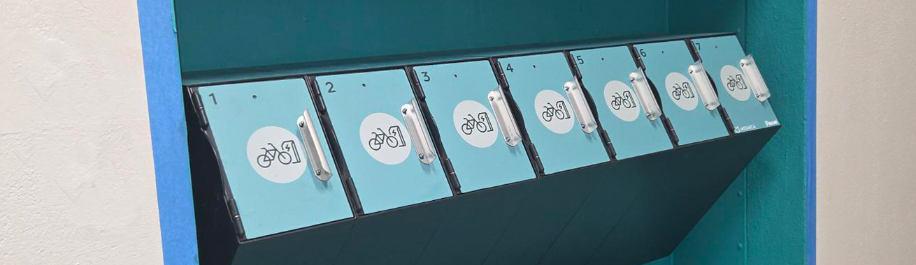 Sju gröna cykelbatteriskåp på väggen