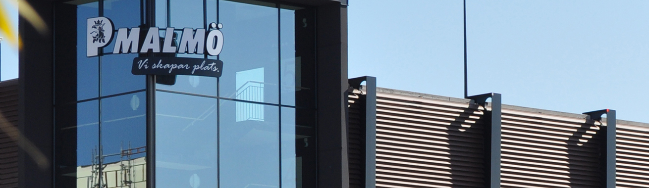 Närbild på P-huset Hyllie Allés fasad där man ser logotypen på ena trapphuset i glas