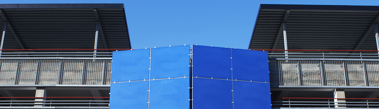 Närbild på P-huset Södervärns fasad där man ser ovankanten av ett blått mittenparti och lite av de övre parkeringsplanen
